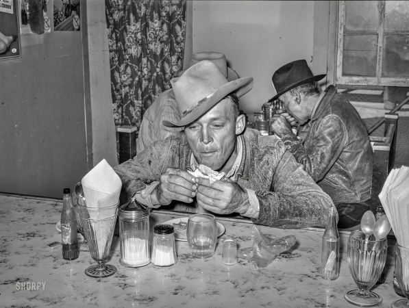 Photo showing: Grub Rustler -- November 1939. West Texan at eating house at auction. Stockyards, San Angelo, Texas.