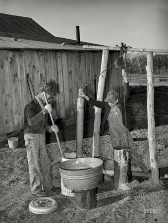 Photo showing: Sons of Pomp -- February 1940. Sons of Pomp Hall, Negro tenant farmer, drawing water
and mixing bran mash to feed the hogs. Creek County, Oklahoma.
