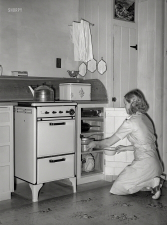 Photo showing: Big as a Breadbox -- May 1940. Wife of member of the Arizona part-time farms. Maricopa County, at her stove.