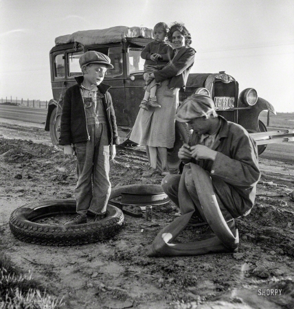 Photo showing: Fix-a-Flat -- March 1937. Migratory agricultural worker family making tire repairs along California highway U.S. 99.
