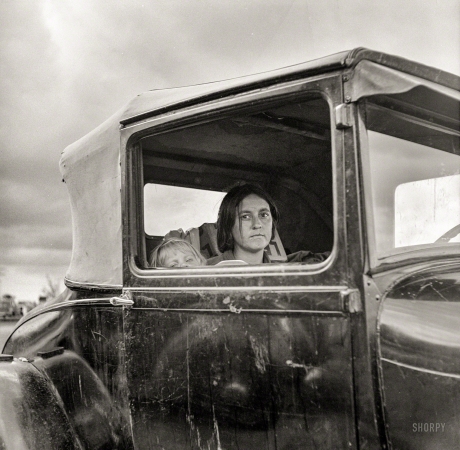 Photo showing: Shafter Strikers -- November 1938. Shafter, California. Wife and child of striking cotton picker waiting
in the car while he applies to the Farm Security Administration for an emergency food grant.