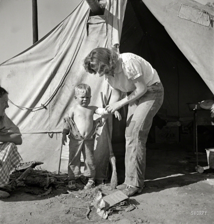 Photo showing: Mommys Little Soldier -- February 1939. In a carrot pullers' camp, Imperial Valley, California. Women from Broken Bow, Oklahoma.