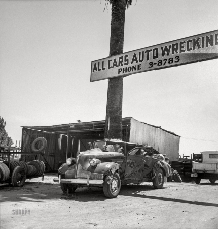 Photo showing: Calling All Cars -- May 1939. U.S. 99 near Tulare, California. Auto wrecking establishments add to the litter which fronts this highway.