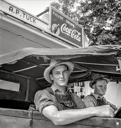 Photo showing: Pause, Drink -- July 1939. Young North Carolinian in old Ford. He does not farm. 'Works for wages.' At Tuck's filling station. Person County, N.C.