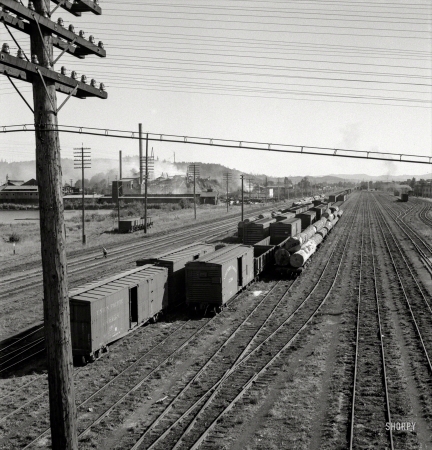 Photo showing: Smoke and Wreckage -- August 1939. Centralia, Washington state. Railroad yard, looking down from highway bridge.
Disaster to the town: The one remaining lumber mill burned down a week before. Note smoke and wreckage.