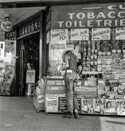 Photo showing: Drugstore Farmboy -- August 1939. Medford, Oregon. Half-grown farm boy on main drugstore corner in town.