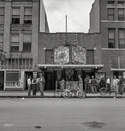 Photo showing: Desert Guns -- June 1937. Oklahoma City. Idle men attend the morning movies. There are three such movies in one block.