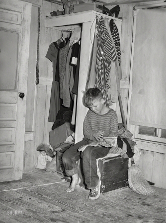 Photo showing: Red Ryder -- December 1940. Corpus Christi, Texas. Small boy, son of carpenter from
Hobbs, New Mexico, reading funny papers in corner of room in tourist court.