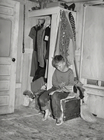 Photo showing: Red Ryder -- December 1940. Corpus Christi, Texas. Small boy, son of carpenter from
Hobbs, New Mexico, reading funny papers in corner of room in tourist court.