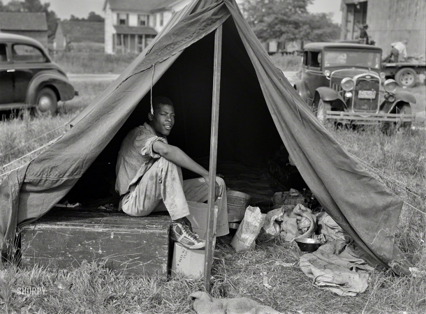 Photo showing: Sick Kicks -- July 1940. Florida agricultural migrant with a group who had their own tent,
which they pitched outside the grading station at Belcross, North Carolina.