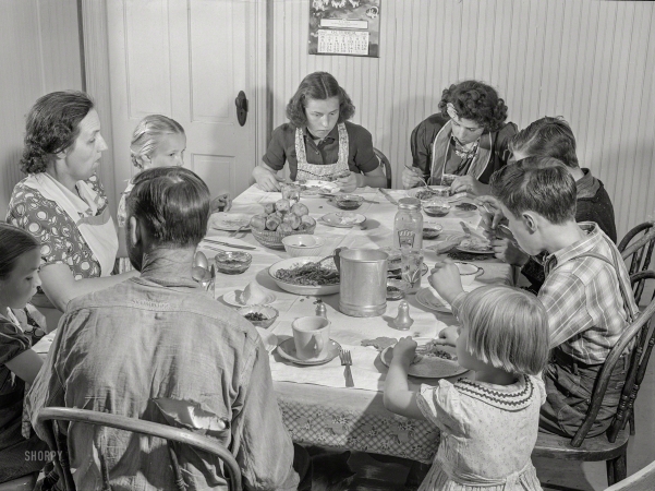Photo showing: Table for Ten -- October 1940. Dinner hour at the home of Mr. J.H. Dube, French-Canadian potato farmer,
after he and the boys had finished a day's work in their potato field in Wallagrass, Maine.