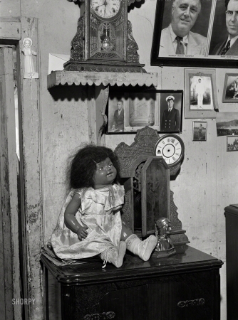 Photo showing: Household Saints -- December 1941. Charlotte Amalie, Saint Thomas Island, Virgin Islands. A colored doll in one of the houses in a slum area.