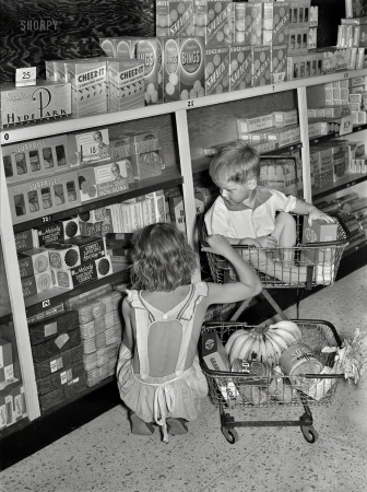 Photo showing: Foxes in the Henhouse -- September 1938. Children buying groceries in co-op store. Greenbelt, Maryland.