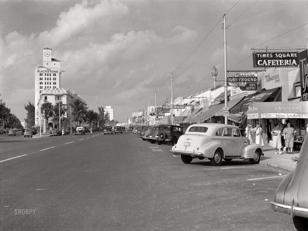 Photo showing: Washington Avenue -- April 1939. Street showing varied small shops, signs, and tourist bureaus. Miami Beach, Florida.