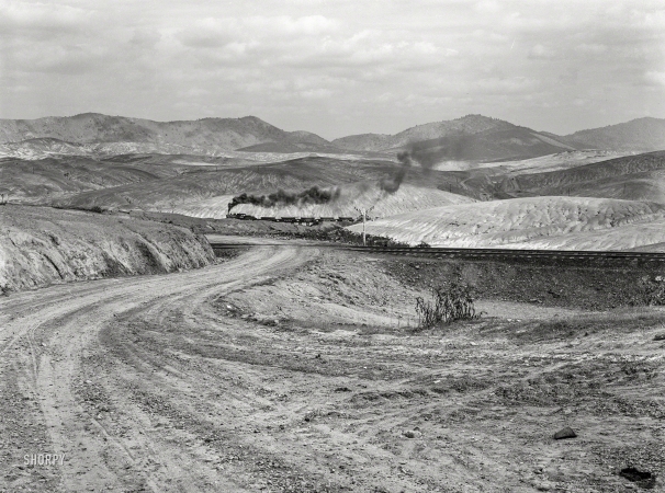 Photo showing: Badland -- September 1939. Ducktown, Tennessee. Train bringing copper ore out of mine. Fumes from
smelting copper for sulfuric acid have destroyed all vegetation and eroded the land.