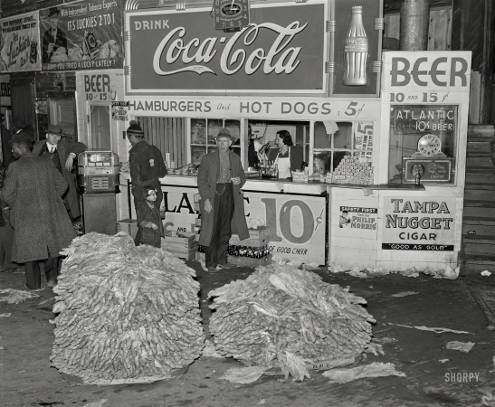 Photo showing: Triple Cola -- November 1939. Lunch stand and tobacco inside entrance to warehouse at end of auction sale. Durham, North Carolina.