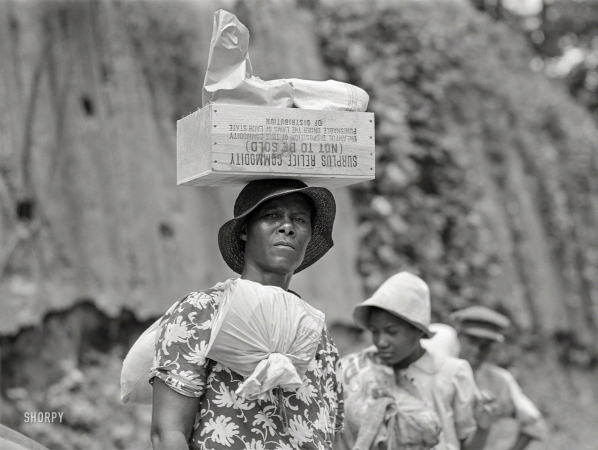 Photo showing: Headstrong -- August 1940. Natchez, Mississippi. Negro women carrying bundles of laundry and boxes on their heads.