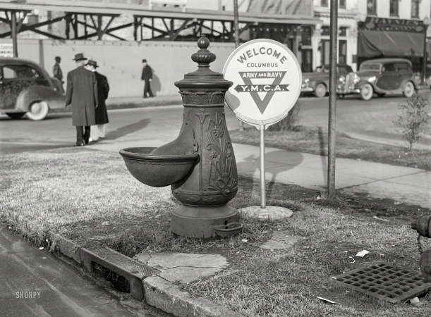 Photo showing: Hydration Station -- December 1940. Columbus, Georgia. Water trough and Y.M.C.A. welcome sign in square in center of town.