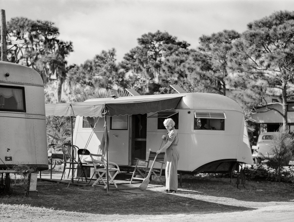 Photo showing: Trailer Life -- January 1941. High class trailer camp at Sarasota, Florida. Sweeping up in front of trailer home.