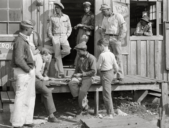 Photo showing: King Me -- February 1941. Belle Glade, Florida. Migratory laborers playing
checkers in front of juke joint during slack season for vegetable pickers.