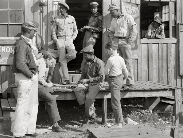 Photo showing: King Me -- February 1941. Belle Glade, Florida. Migratory laborers playing
checkers in front of juke joint during slack season for vegetable pickers.
