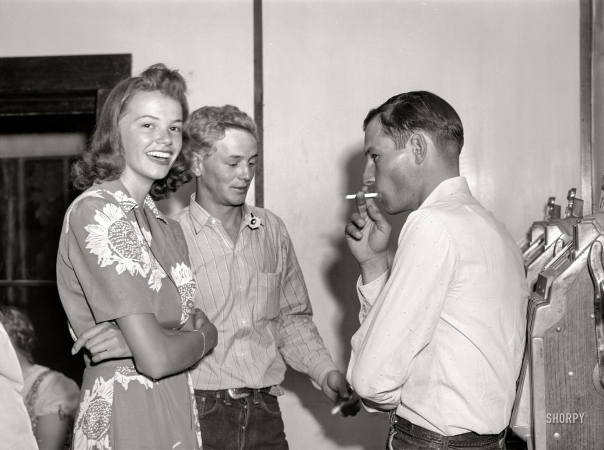 Photo showing: Dude Girl -- August 1941. Dude girl with two cowboys at a Saturday night dance in Birney, Montana.