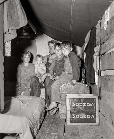 Photo showing: The Cherry Pickers. -- July 1940. Migrant fruit worker and sons living in rear of truck
during cherry picking season. Berrien County, Michigan.