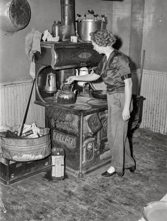 Photo showing: This Old Stove -- July 1940. Door County, Wisconsin. Wife of FSA rehabilitation borrower in her kitchen.