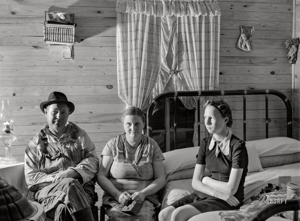 Photo showing: Knotty and Nice -- November 1940. Agricultural day laborer, wife and daughter in new home built by FSA. New Madrid County, Missouri.
