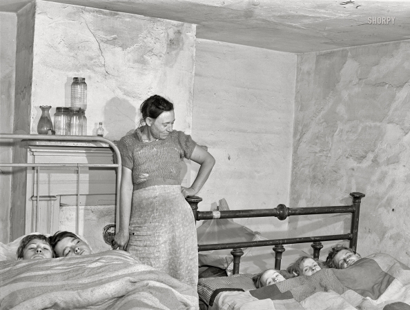 Photo showing: Tucked In -- March 1941. Mother and children from North Carolina farm. They came to Norfolk, Virginia ... 