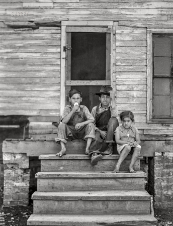 Photo showing: A Light Lunch -- August 1941. Children of Mexican sugar beet worker
on porch of one of the houses at Saginaw Farms, Michigan.