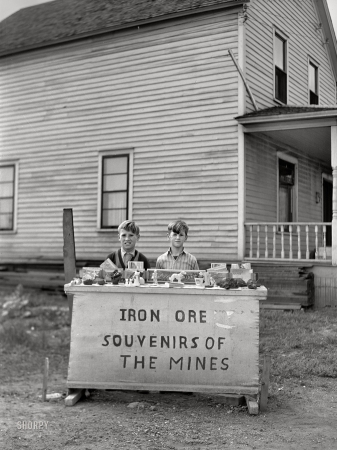 Photo showing: Ore of Yore -- August 1941. Children of old Hibbing, Minnesota,
sell pieces of ore and iron range souvenirs to tourists.