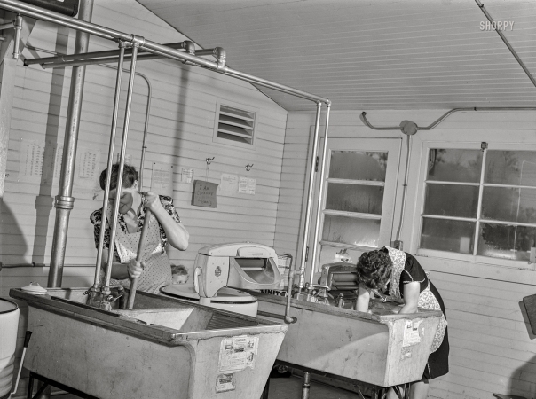 Photo showing: Granitine Gals -- February 1942. Burlington, Iowa. Acres Unit, Farm Security Administration
trailer camp. In the utility building for workers at Burlington ordnance plant.