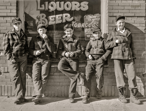 Photo showing: Cinco de Boyo -- February 1942. Roscoe, South Dakota. Younger boys are standing in front of the pool halls this year.