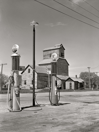 Photo showing: Sky Chief. -- May 1942. Gothenburg, Nebraska. Gas station and grain elevator.
