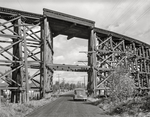 Photo showing: Cowlitz Crossing -- October 1941. Cowlitz County, Washington. Highway goes under wooden trestle for railroad.