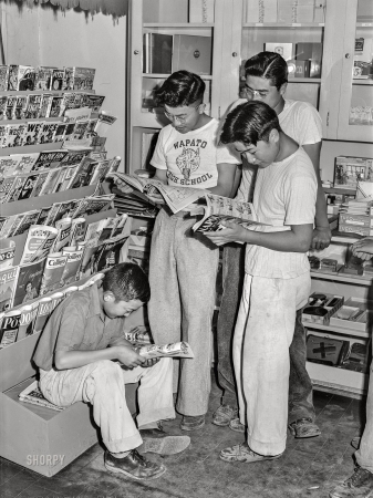 Photo showing: Comic-Con: 1942 -- July 1942. Nyssa, Oregon. Japanese-American boys at the newsstand on their weekly visit to town.