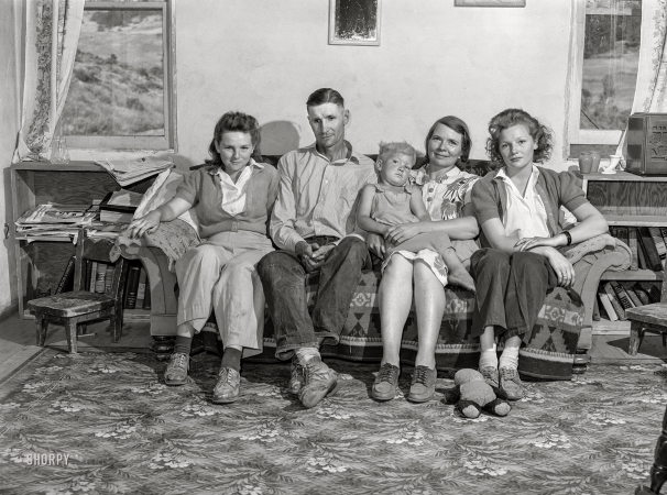 Photo showing: Sofa So Good -- July 1942. Ola, Idaho. A member of the self-help cooperative and his family at home.