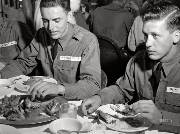 Photo showing: The Third Bird -- August 1941. Poultry raised under 'Food for Defense' program feeds Army flight trainees.