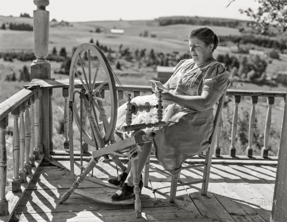 Photo showing: Spinning a Yarn -- August 1942. Fort Kent, Maine (vicinity). Wife of Leonard Gagnon, Acadian FSA client, spinning wool for knitting.