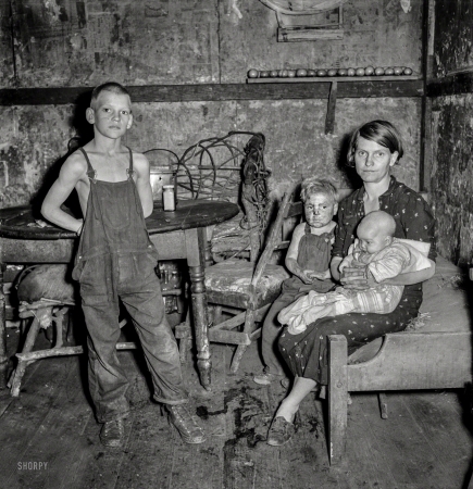 Photo showing: Children of the Coal -- September 1938. Coal miner's wife and three of their children. Company house in Pursglove, Scotts Run, West Virginia.