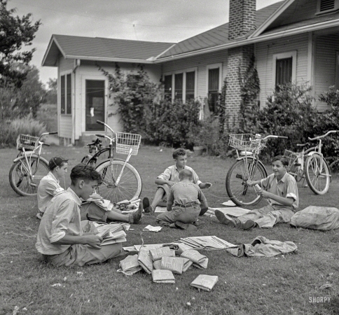 Photo showing: Grass Routes -- July 1940. Boys in Natchitoches, Louisiana, folding papers before delivering them in the afternoon.