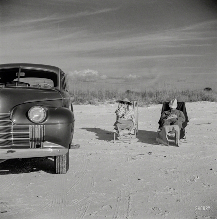 Photo showing: Unhitched -- January 1941. Guests of Sarasota, Fla., trailer park enjoying the sun and sea breeze at the beach.