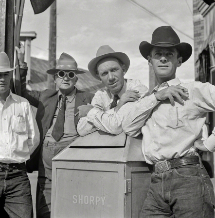 Photo showing: New West -- August 1941. Stockmen on street corner outside bar 'The Mint.' Sheridan, Wyoming.