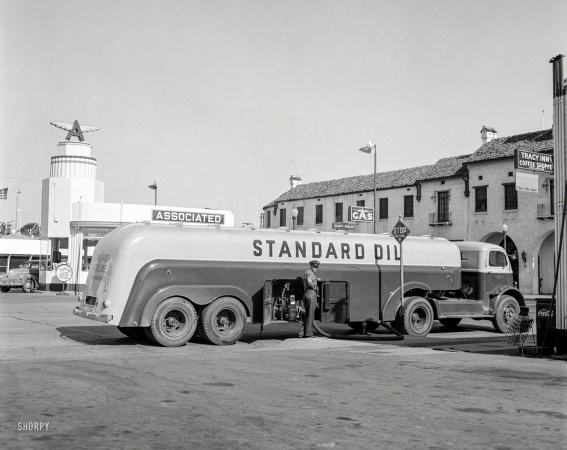 Photo showing: Fill Er Up! -- June 1942. Tracy, California. Tank truck delivering gasoline to a filling station.