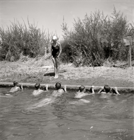 Photo showing: The Swimming Lesson -- July 1942. Rupert, Idaho. Schoolboys in swimming lesson.