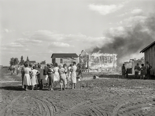 Photo showing: Fully Involved -- January 1939. Lake Harbor, Florida. Negro agricultural laborers watching one of their houses burn to the ground.