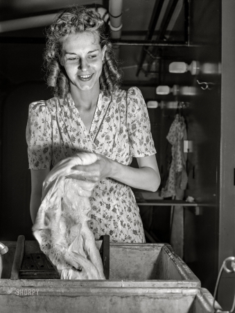 Photo showing: Erie Laundry -- June 1941. Wife of defense worker washing clothes in utility building at FSA trailer camp. Erie, Pennsylvania.