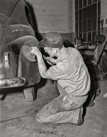 Photo showing: That Should Buff Right Out -- May 1942. Arlington, Virginia. Operations in auto body plant and storage of 'frozen' cars.