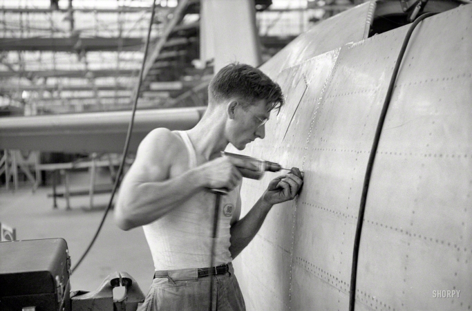 Photo showing: Danny the Driller -- August 1942. Vultee Aircraft Co, Nashville. Drilling holes for rivets in a fuselage on a sub-assembly line.